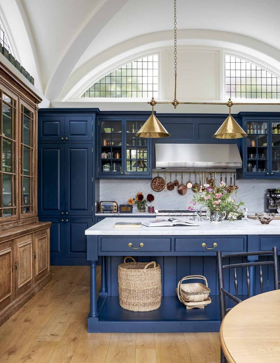 2 polished brass kitchen lamps against blue kitchen cabinets