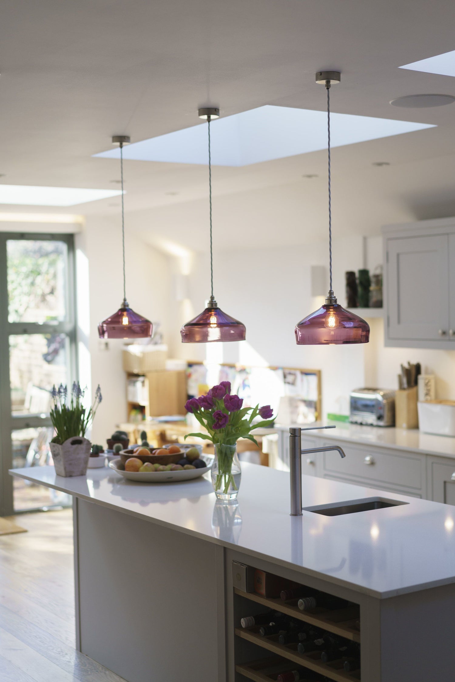 3 glass kitchen pendant lights above a countertop